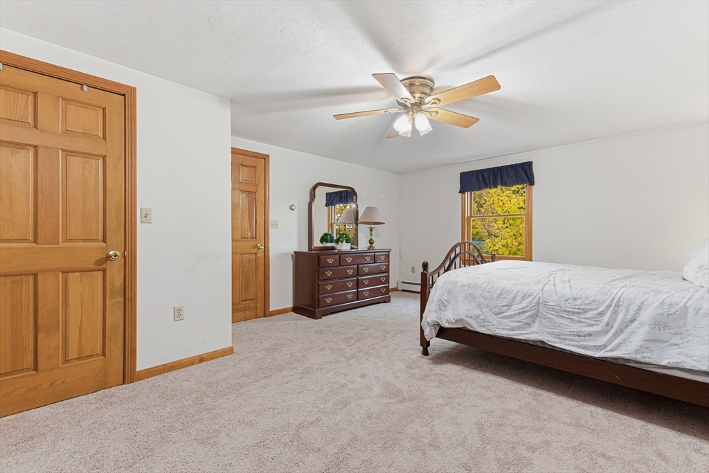 7 John Street Southborough, MA 01772 - Photo 19 of 30 a spacious bedroom with a bed a dresser and a chandelier
