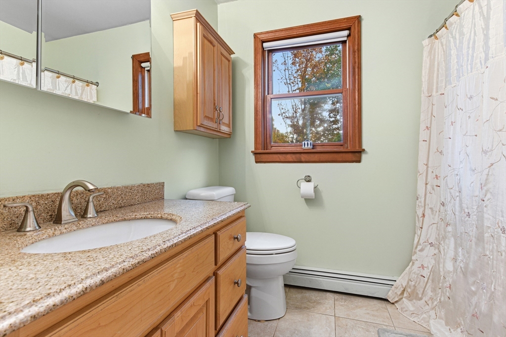 7 John Street Southborough, MA 01772 - Photo 22 of 30 a bathroom with a granite countertop sink mirror vanity and toilet