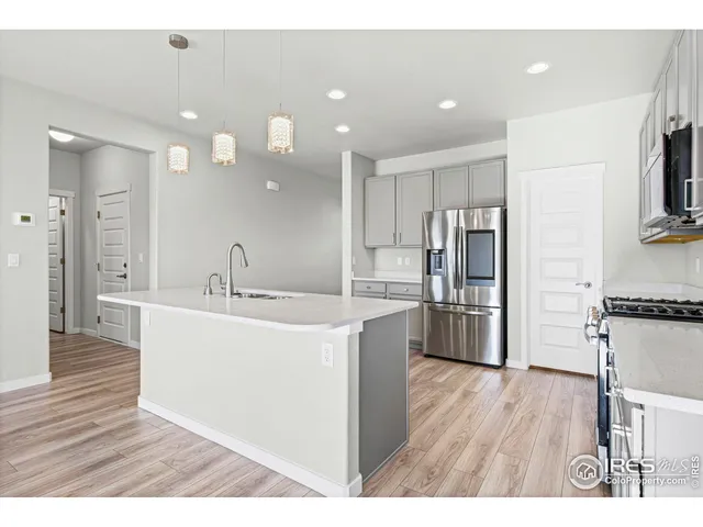 a view of kitchen with refrigerator microwave and wooden floor