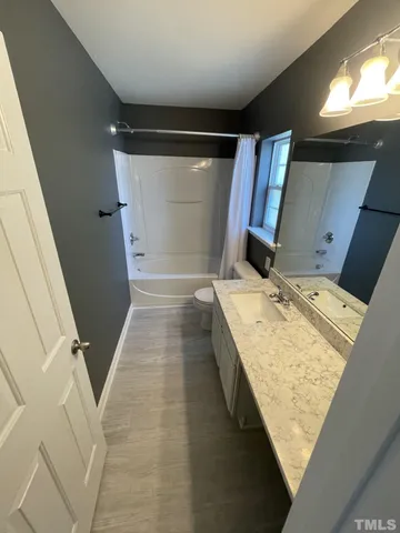 a bathroom with a tub sink and mirror