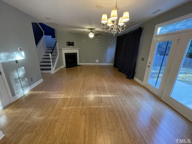a view of a room with wooden floors and chandelier
