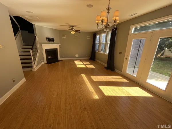 a view of a livingroom with wooden floor and a ceiling fan