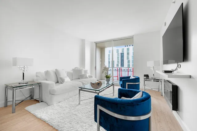 a living room with furniture a large window and a flat screen tv