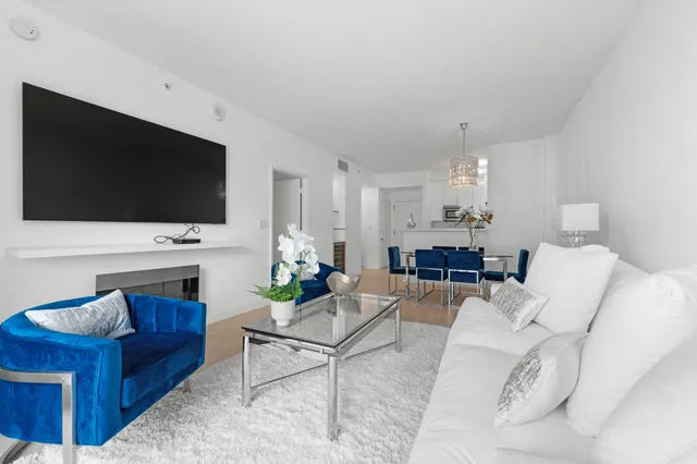 a living room with furniture a flat screen tv and a fireplace