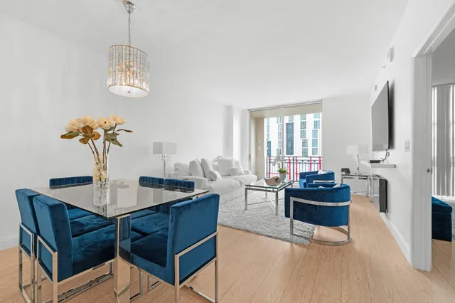 a view of a dining room with furniture a chandelier and wooden floor