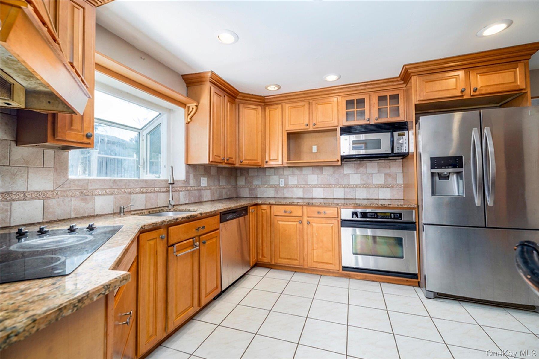 3447 Steven Road Baldwin, NY 11510 - Photo 6 of 23 a kitchen with stainless steel appliances granite countertop a sink stove refrigerator and cabinets