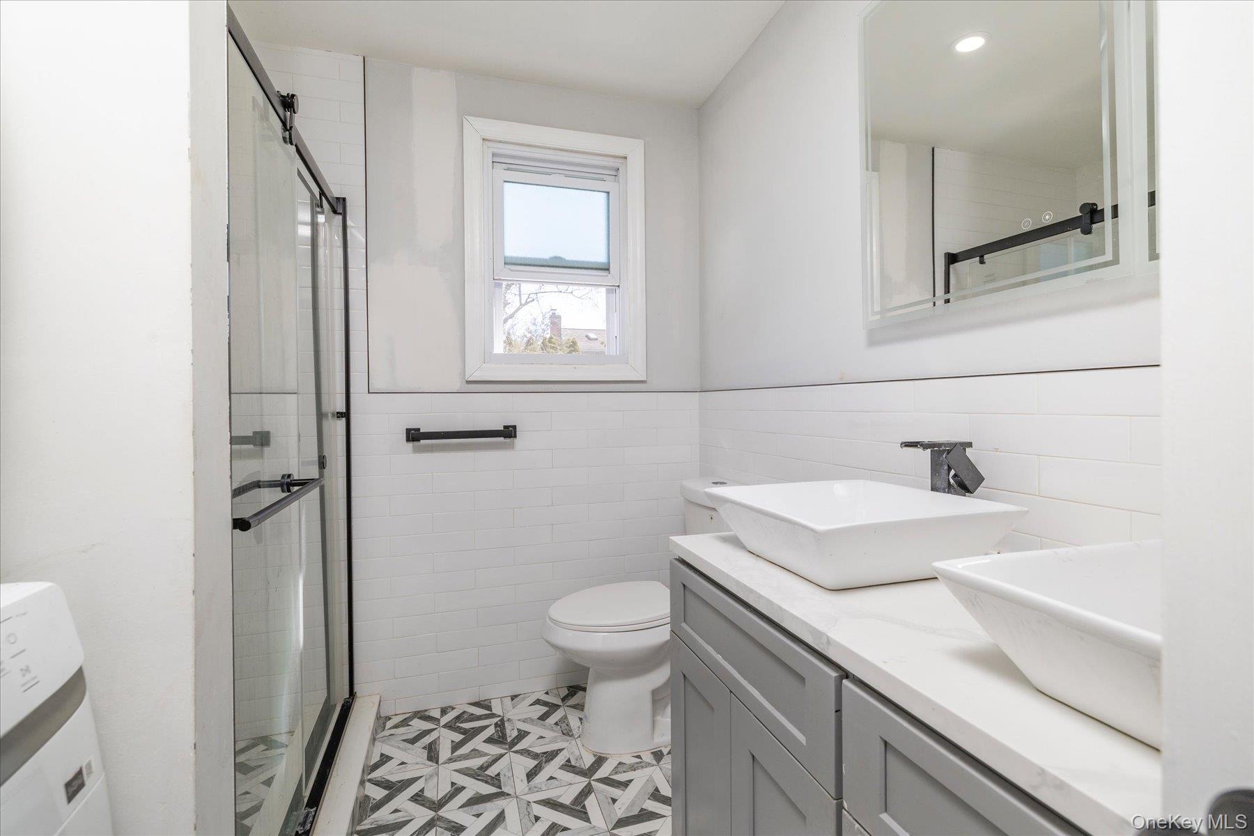 3447 Steven Road Baldwin, NY 11510 - Photo 10 of 23 a bathroom with a sink a toilet and shower
