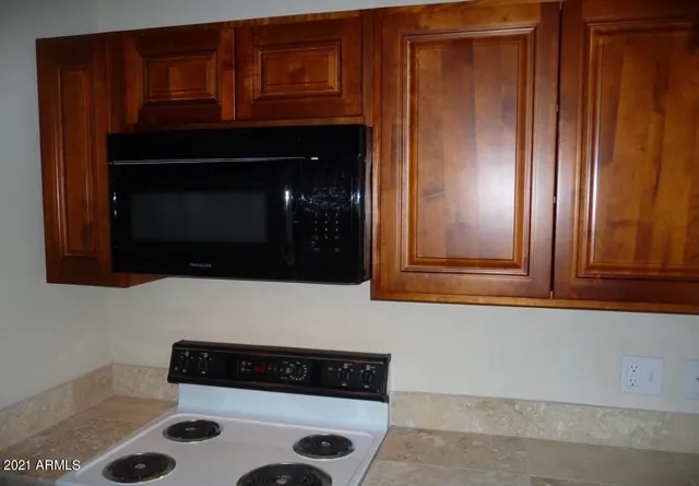 a kitchen with granite countertop white cabinets and black appliances