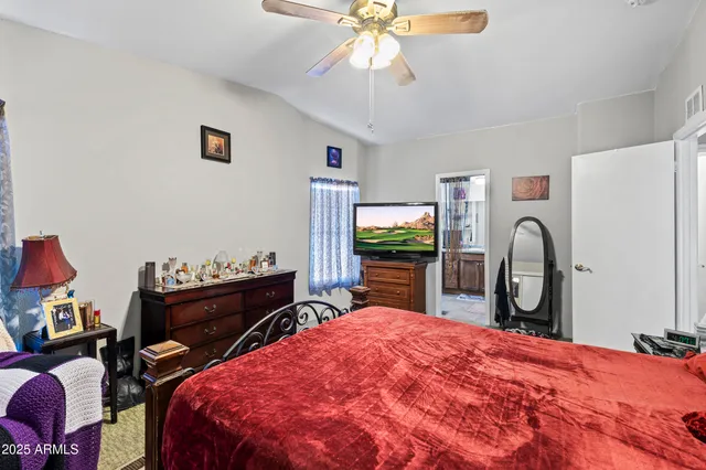a bedroom with a bed and a flat tv screen on dresser