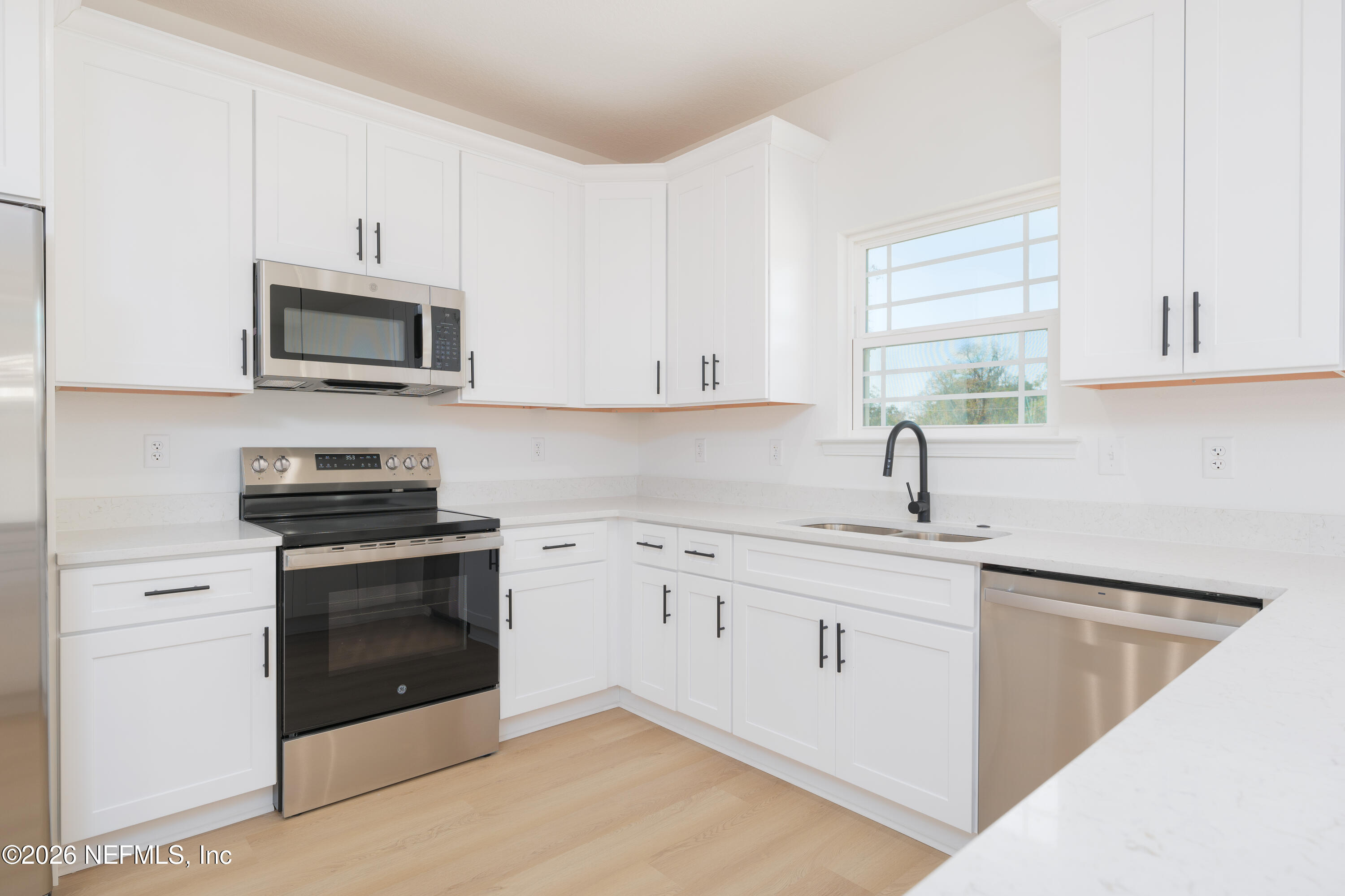 5573 Oregon Trail Middleburg, FL 32068 - Photo 5 of 26 a kitchen with granite countertop a sink dishwasher stove and microwave with wooden cabinets