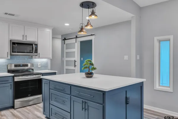 a kitchen with a sink a stove and cabinets