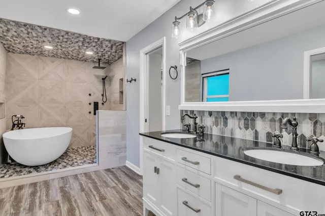 a bathroom with a granite countertop sink mirror toilet and bathtub