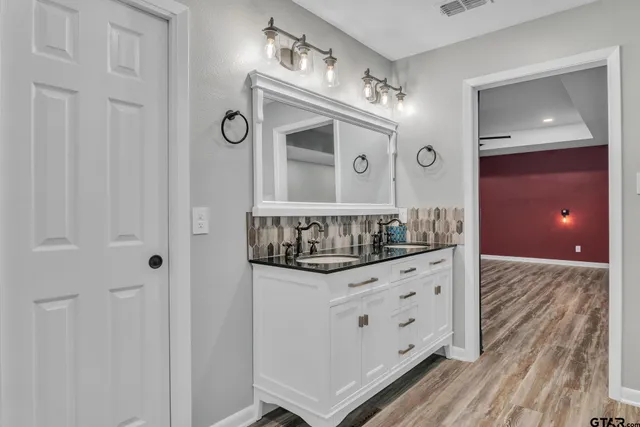 a bathroom with granite countertop a sink and a mirror