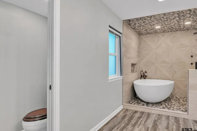 a spacious bathroom with a granite countertop sink and a mirror
