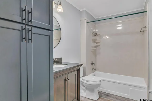 a bathroom with a granite countertop toilet a sink and a mirror