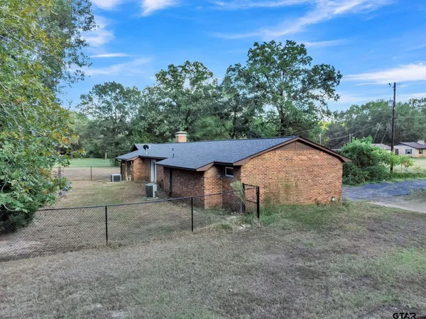 a view of a house with a yard and large tree