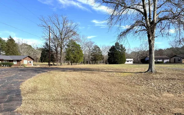 a view of a white house with a yard covered with snow