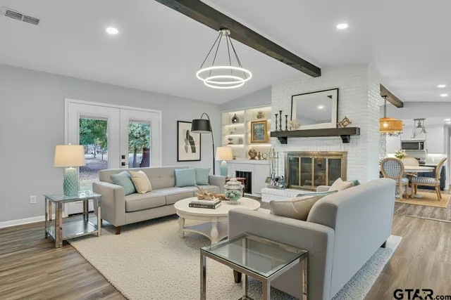 a living room with fireplace furniture and a large window