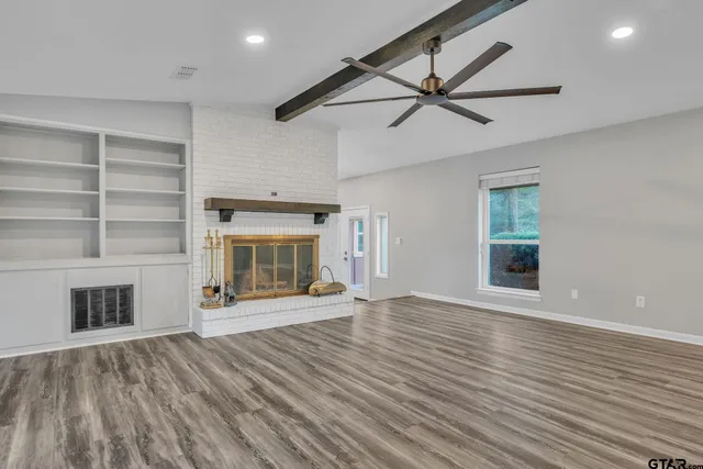 a view of an empty room with a fireplace and a window