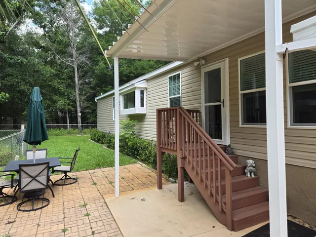 a view of a chair and table in backyard of the house