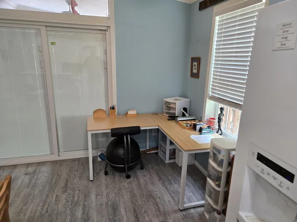 a view of a workspace with furniture and wooden floor