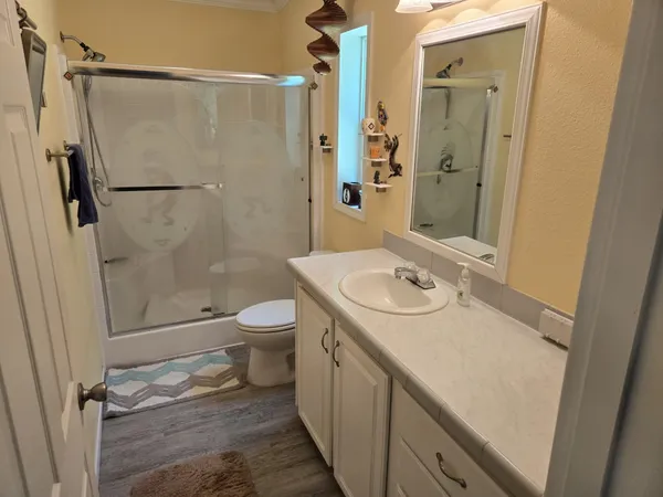a bathroom with a granite countertop sink toilet and shower