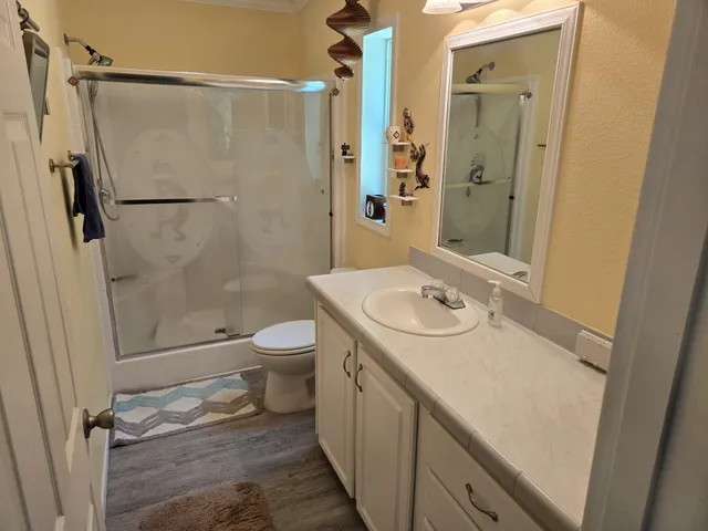 a bathroom with a granite countertop sink toilet and shower