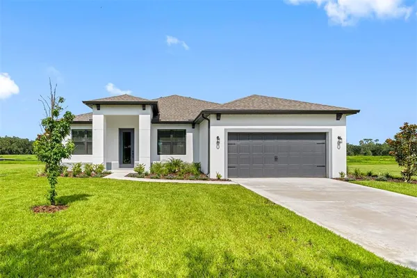 a front view of a house with a yard and garage