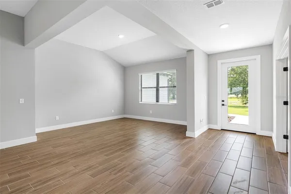 an empty room with windows and wooden floor