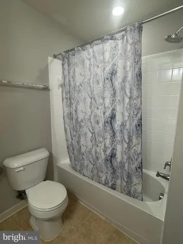 a white toilet sitting next to a shower curtain