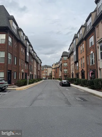 a city street lined with buildings and a cars parked on the side of road