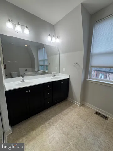 a spacious bathroom with a double vanity sink and a mirror