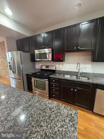 a kitchen with stainless steel appliances granite countertop a sink and a stove