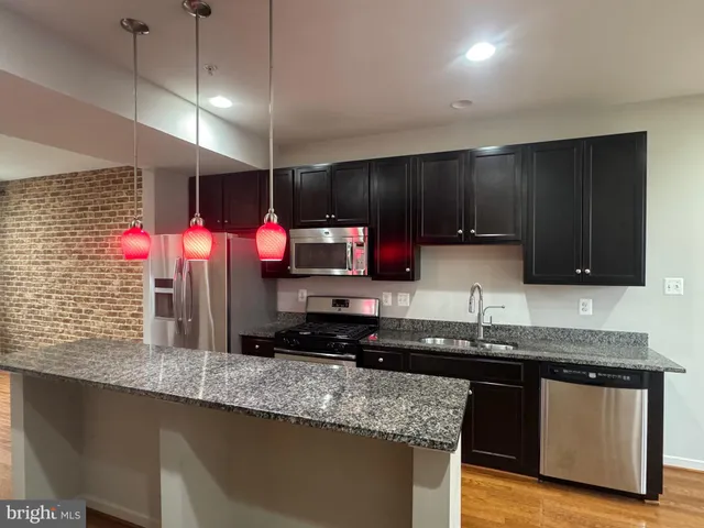a kitchen with stainless steel appliances granite countertop a refrigerator and a sink