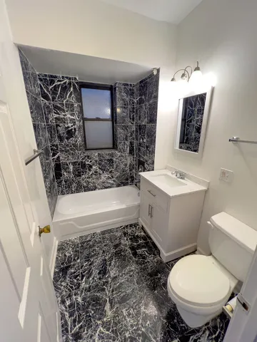 a bathroom with a toilet sink and mirror