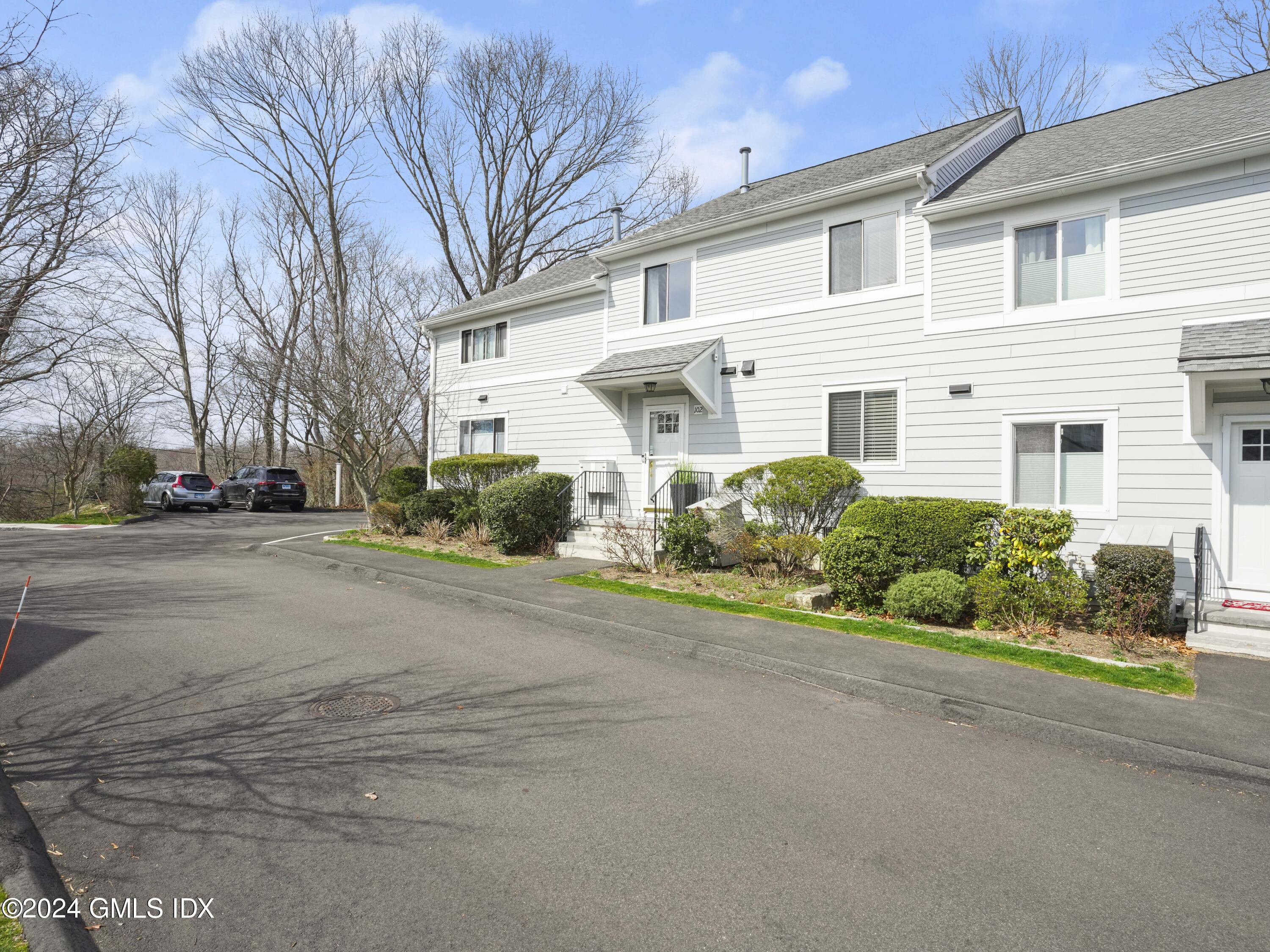 102 Silo Circle, Unit 102 Riverside, CT 06878 - Photo 2 of 22 a front view of a house with a yard and garage