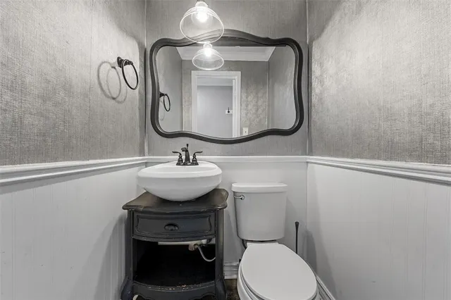 a bathroom with a toilet sink and mirror