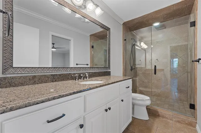 a bathroom with a granite countertop sink mirror and toilet