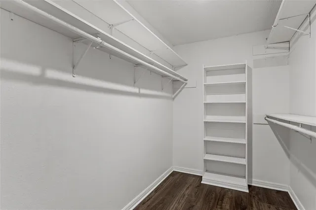 a view of walk in closet with empty racks