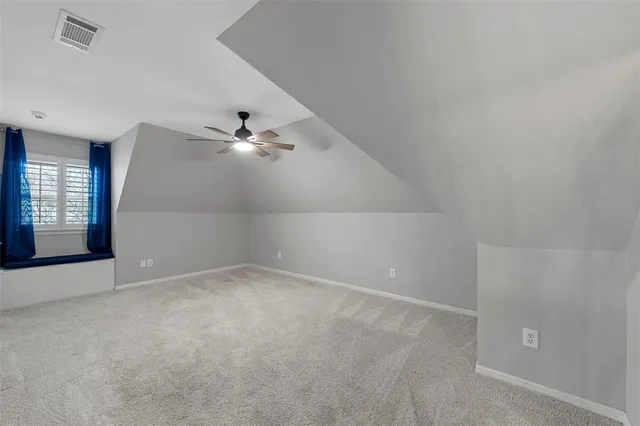 an empty room with windows and ceiling fan