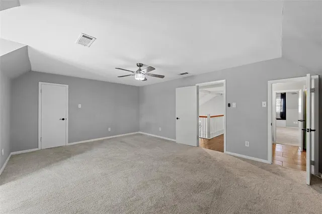 a view of an empty room with closet and a window