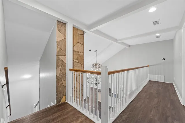 a view of a hallway with wooden floor and stairs