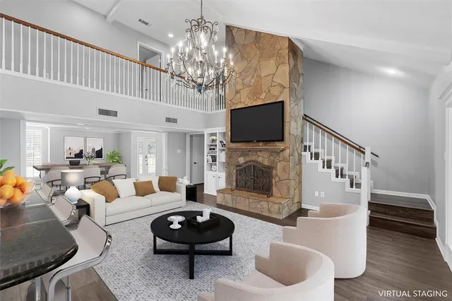 a living room with furniture a chandelier and a flat screen tv
