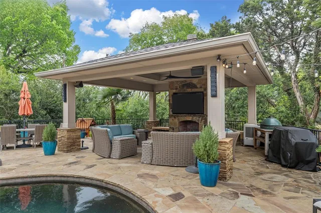 a view of a patio with couches chairs potted plants and floor to ceiling window