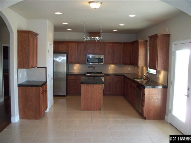 4891 Rancheria Road Fallon, NV 89406 - Photo 3 of 13 a kitchen with stainless steel appliances granite countertop a refrigerator and a sink