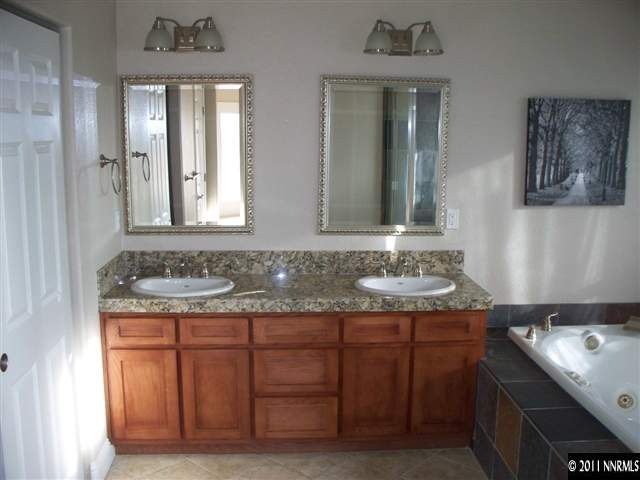 4891 Rancheria Road Fallon, NV 89406 - Photo 5 of 13 a bathroom with a granite countertop sink and a mirror