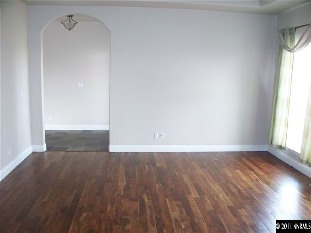 4891 Rancheria Road Fallon, NV 89406 - Photo 9 of 13 an empty room with wooden floor and windows