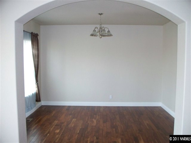 4891 Rancheria Road Fallon, NV 89406 - Photo 10 of 13 an empty room with wooden floor and windows