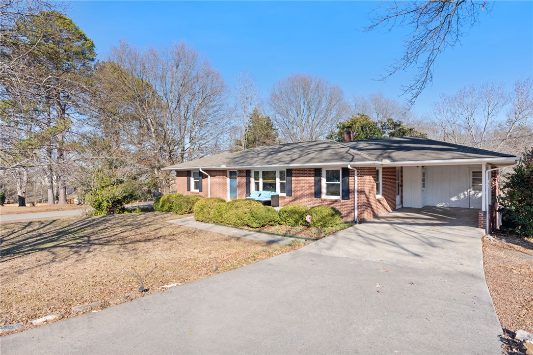 This classic brick residence features a spacious driveway and convenient carport, offering easy access.