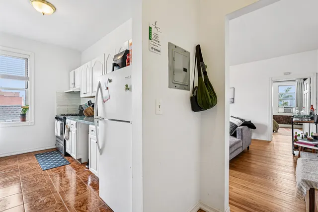a kitchen with stainless steel appliances a refrigerator and a wooden floor